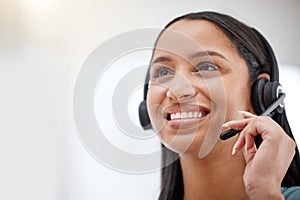 One young hispanic happy and cheerful female call center agent wearing a headset and working in customer service at work