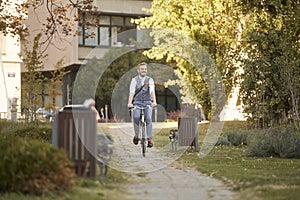One young man, 20-29 years old, wearing hipster suit, smart casual, smiling, enjoying riding bike in park road trail