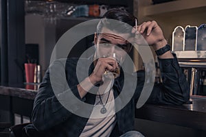one young man only, handsome sideways glance drinking spirit alcohol drink bar