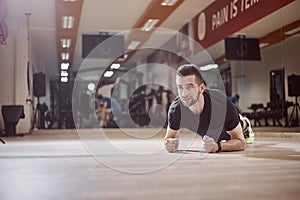 One young man, looking away, plank exercise, gym floor,