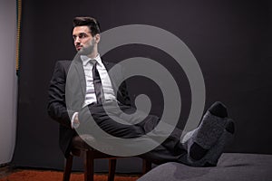 One young man sitting chair relaxing socks suit