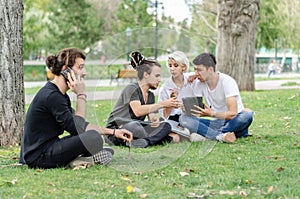 One young man speaks on the mobile phone.A group of earnestly working in the background with the laptop