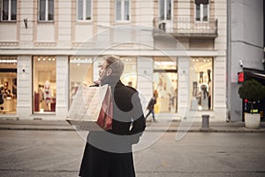 One young mans back, rear view, 20-29 years old, handsome and stylish, standing on a pedestrian street in city, looking,