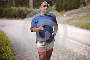 One young overweight man, 30-35 years, outdoors nature, jogging,
