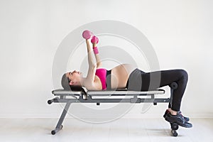 One young pregnant woman doing fitness exercises