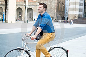 One young stylish man riding his bicycle in the city
