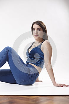 One young teenage girl, posing in studio, laying on floor, unusual attitude,