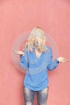 One young woman, 20-29 years old, messy chaotic long blond hair, almost hilarious since her face can `t be seen, arm`s raised in d