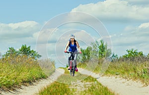 One young woman - an athlete in a helmet riding a mountain bike outside the city