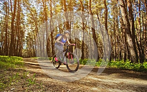 One young woman - cyclist in a helmet riding a mountain bike outside the city