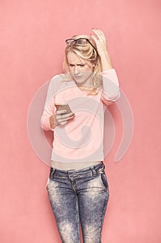 One young woman looking to her smart phone, while in disbelief using it