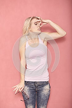 One young woman, smelling something bad, holding her nose,