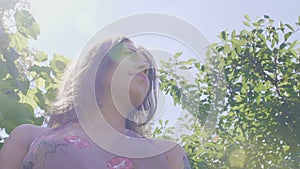 Oneness with nature, woman in garden among fruit trees, low angle, sun rays slow