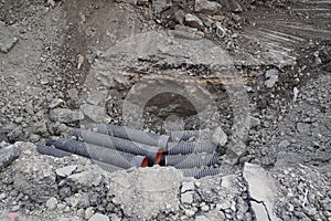 Ongoing construction works going on an Indian Street. Construction machine has dug up a trench in a road. Main street. Trench dug