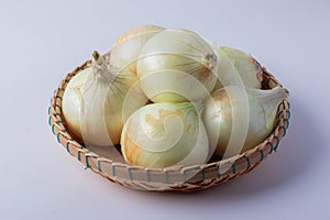 Onion in a bamboo basket on a white background