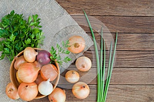 Onion in bowl on sacking and wooden background