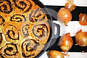 Onion bread rolls in ironcast pan, fresh golden onion