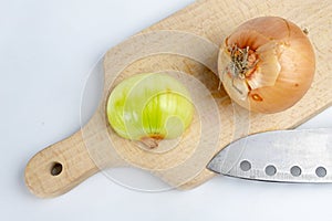 Onion on a chopping board on a white kitchen table. Vegetables f