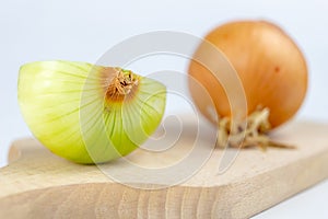 Onion on a chopping board on a white kitchen table. Vegetables f