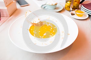 Onion cream soup with toast. Vegetable cream soup with pumpkin in a white bowl and a slice of bread with cheese. Healthy food. Hea