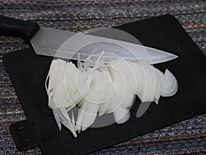 Onion cut with knife in thin slices for cooking ingredient photo