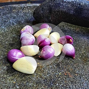 Onion and garlic on a stone before mashing