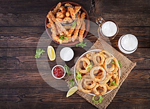 Onion rings in batter with sauce and cheese sticks. Beer snacks.