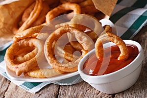 Onion rings in tomato sauce closeup. horizontal on the table