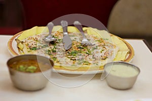 Onion Uttapa or Uttapam served with coconut chutney and sambar. A true south Indian delight.