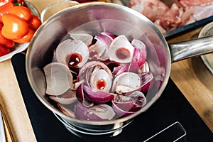 Onions borettane pickles in a saucepan filled with red wine. Delicacy, a dish from the chef.