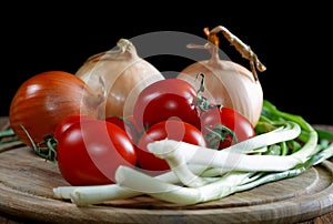 Onions napiform tomatoes on an old table