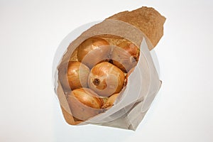 Onions in a paper bag, white background, fruit and freshness, aphorisms written on paper photo