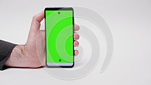 Online advertising. Close-up of man's hand holding smartphone with green screen on white background. Woman swipes at