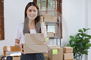 Online business concept, Asian business women holds parcel boxes of product for delivery to client