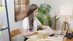 Online business concept, Asian business women packing product into parcel box for prepare delivery