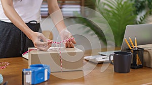 Online business concept, Asian business women packing product into parcel box and tying with rope