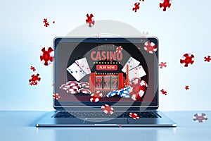Online casino and gaming, gambling on device concept. Close up of laptop computer at work place with creative slot machine and