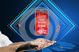Online casino and gaming, gambling on device concept. Close up of male hands holding smartphone with creative slot machine and