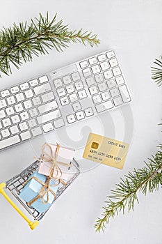 Online christmas shopping concept with gift boxes, keyboard and golden credit card