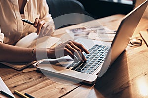 Always online. Close up of young woman working using computer while sitting in her workshop