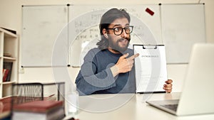 Online coding courses. Young man, male teacher in glasses looking at webcam and teaching Python online, working at home