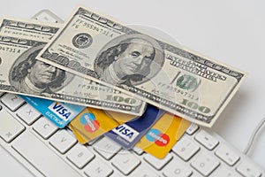 Online Commerce, Ecommerce, credit and debit cards with dollars and a keyboard.