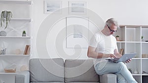 online communication relaxed man using laptop home