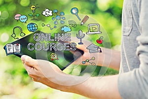 Online Courses concepts with young man holding his tablet computer photo