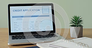 Online Credit Application form showing on a laptop computer screen sitting on a desk.