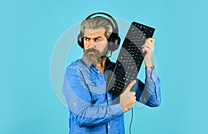 Online Cyber e-Sport Internet. gamer playing computer game. Digital Music Creation. bearded man headphones and keyboard