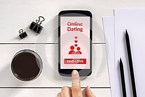 Online dating app mock up on smart phone screen with office objects