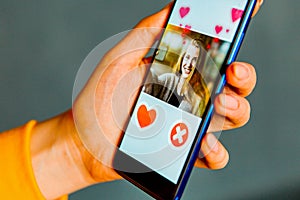 Online dating app in smartphone. Man looking at photo of beautiful woman. Person swiping and liking profiles on