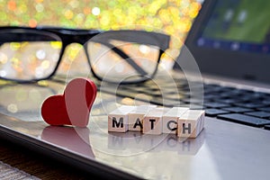 Online Dating concept with laptop red heart shape and wood word match