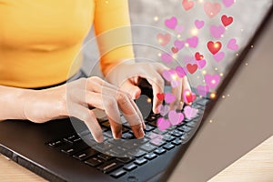 Online dating concept with woman hand chatting on computer hand typing on keyboard with heart shape